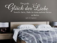 Zitat Wandtattoo Das große Glück der Liebe... in weiß über dem Bett