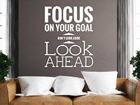 Wandtattoo Focus on your goal in weiß über der Couch im Wohnzimmer