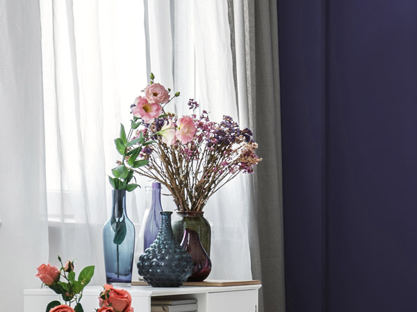 Violette Wand mit Blumendeko im Vordergrund