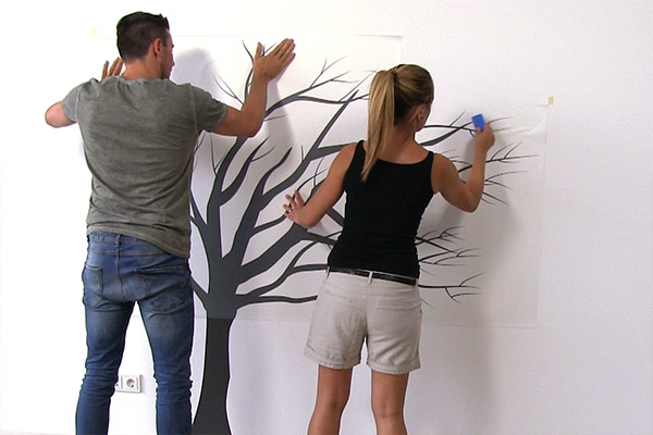 den Wandtattoo Baum festdrücken